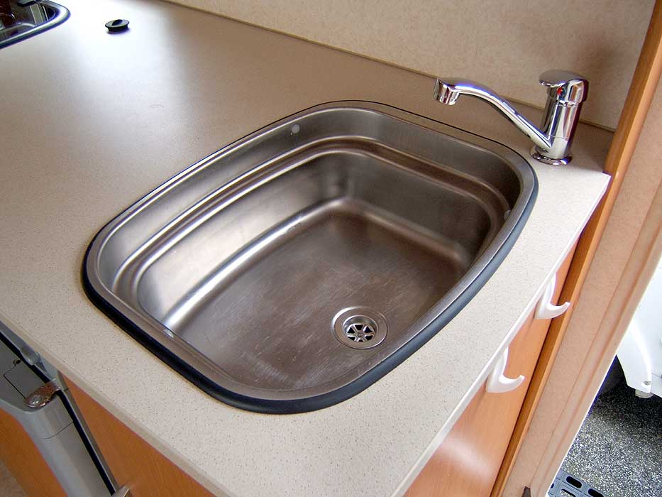 The stainless steel sink with single mixer tap.